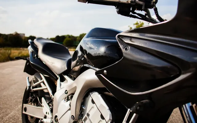 Black motorbike parked on a quiet country road
