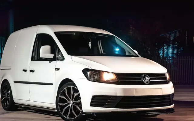 White panel van parked on a city street at night